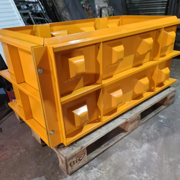 Yellow interlocking concrete block mould on a pallet