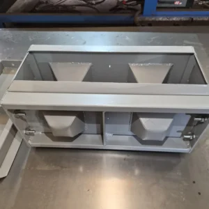 Small grey block mould sat on a reflective table